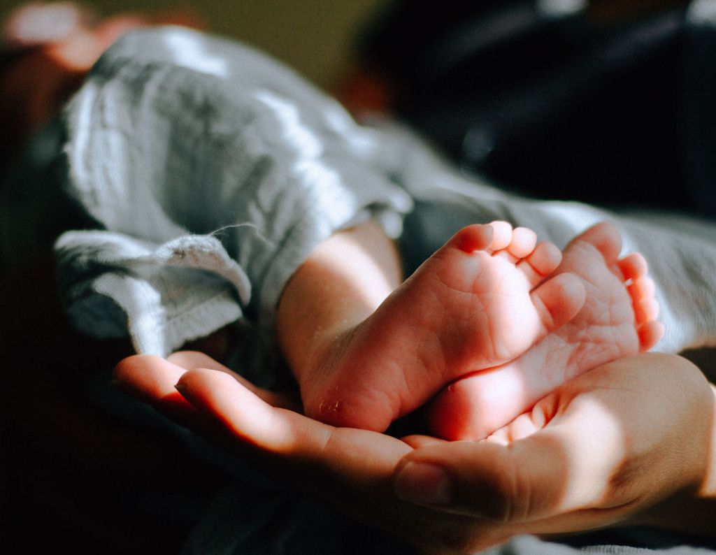 Infant's foot held in an open hand.